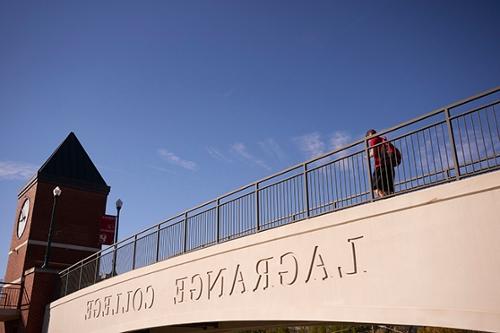 student crossing the 威尼斯人娱乐城大学 pedestrian bridge, 哪个侧面刻着学校的名字